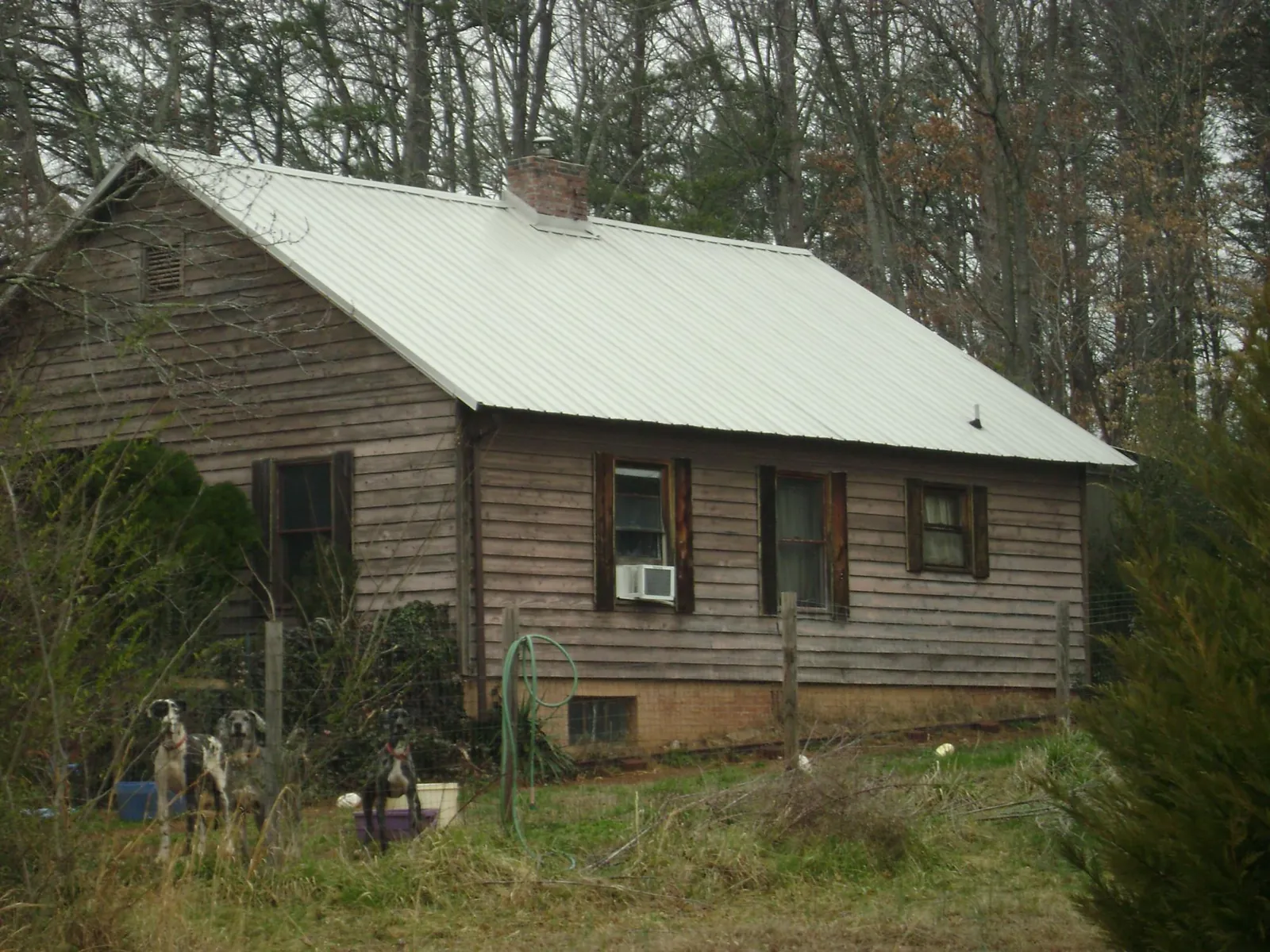 White metal roof on an old wood sided farmhouse, from a Metal Roof Installation job in Champlain